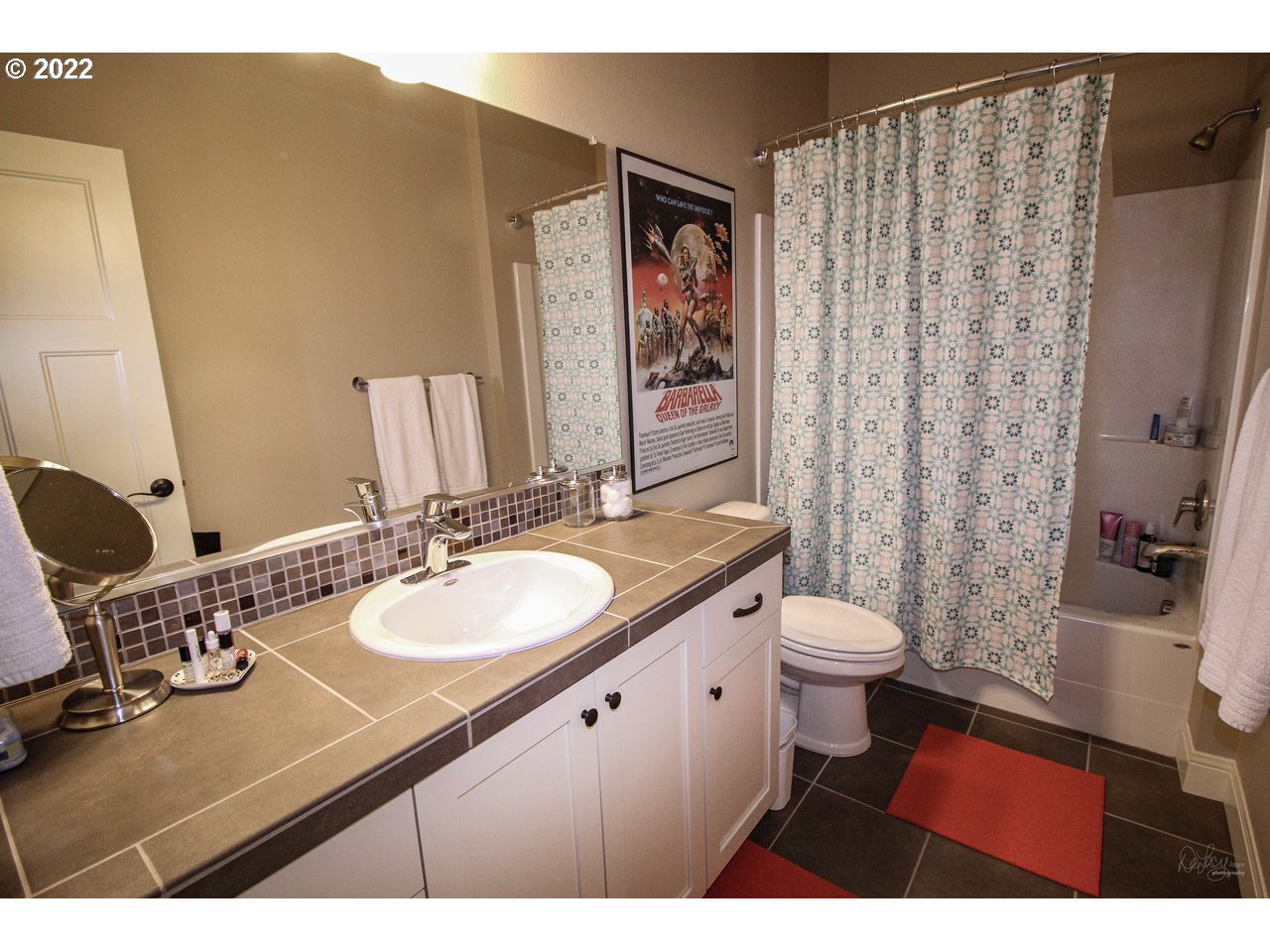 14174 Southwest Compass Drive Beaverton, OR 97005 - Photo 22 of 32 a bathroom with a sink a toilet a mirror and shower curtain