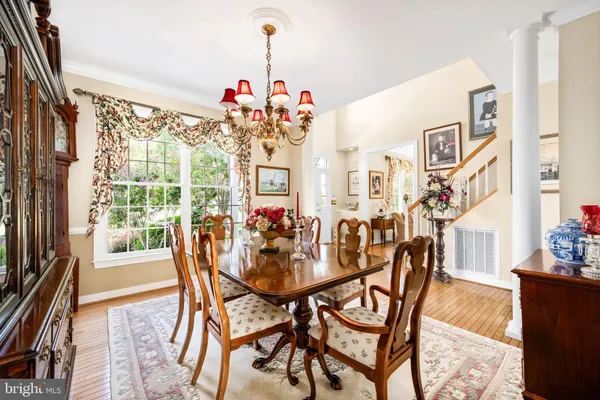 a view of a dining room and livingroom with furniture wooden floor a chandelier