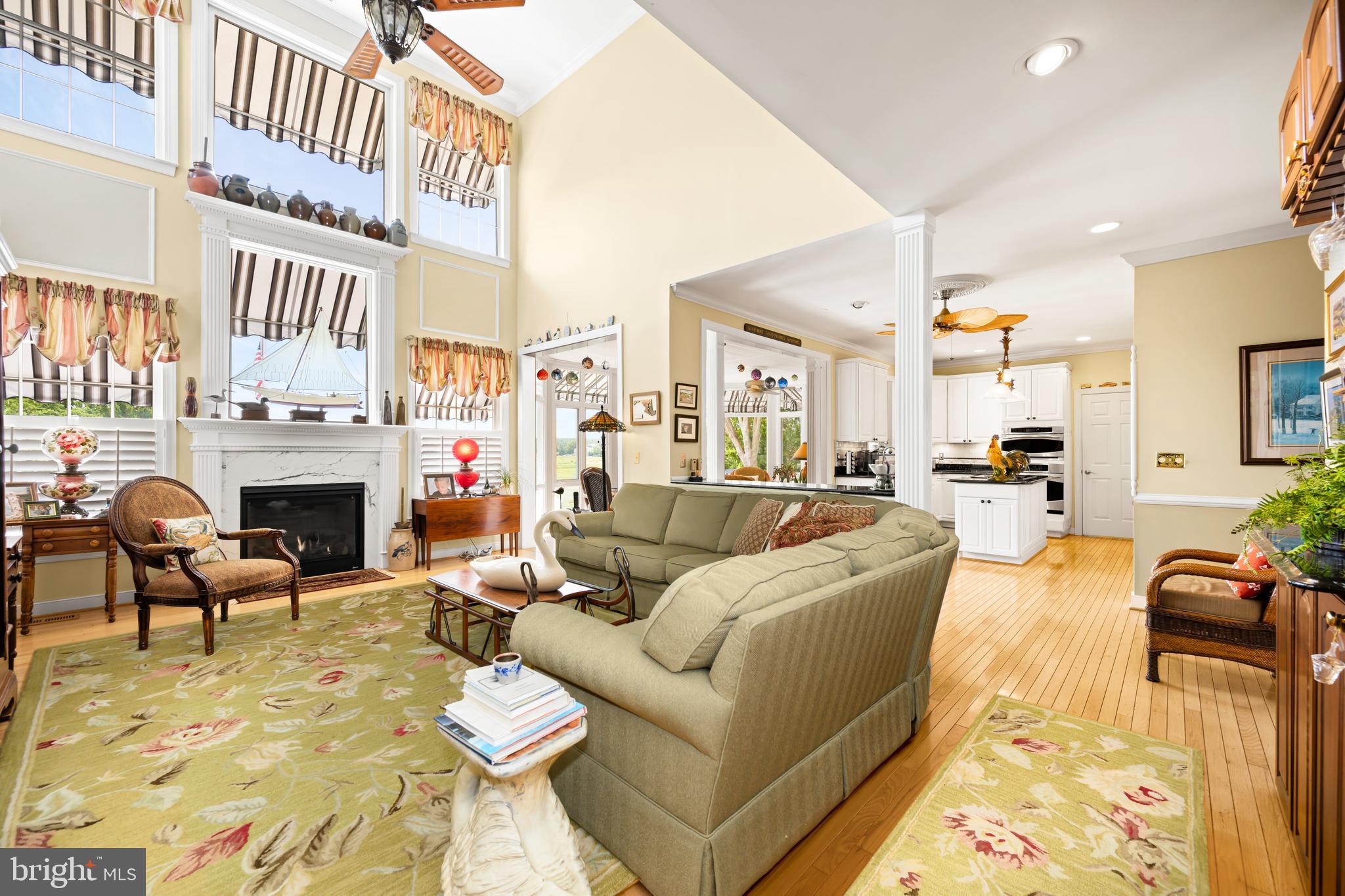 21477 Island Club Road Tilghman, MD 21671 - Photo 23 of 50 a living room with furniture a fireplace and a kitchen view