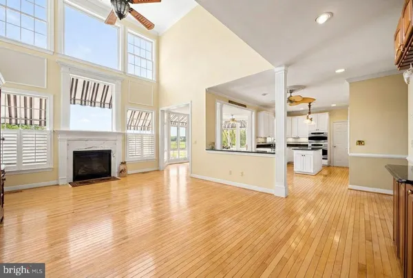 a view of a living room kitchen with stainless steel appliances wooden floor and a large window