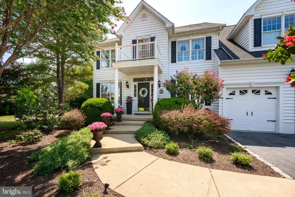 a front view of a house with a yard and a garden