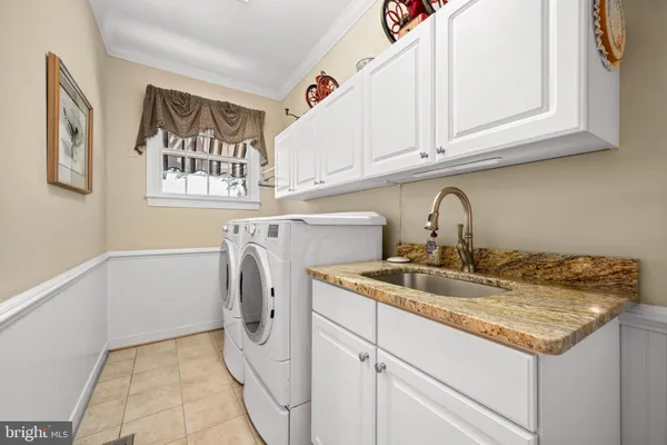a utility room with sink dryer and washer