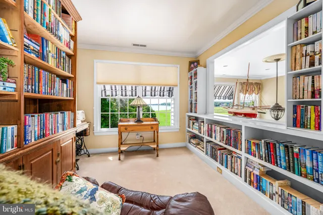 a living room with large lots of books and a book shelf