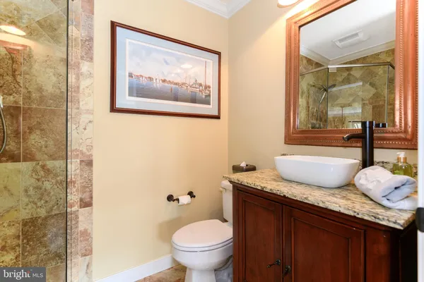 a bathroom with a granite countertop sink mirror vanity and toilet