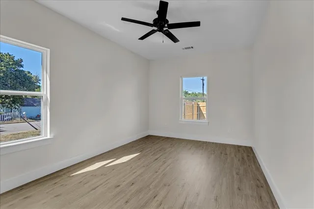 a view of room with window wooden floor and a ceiling fan