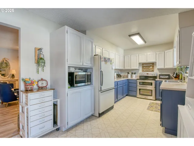 a kitchen with kitchen island a counter top space stainless steel appliances and cabinets