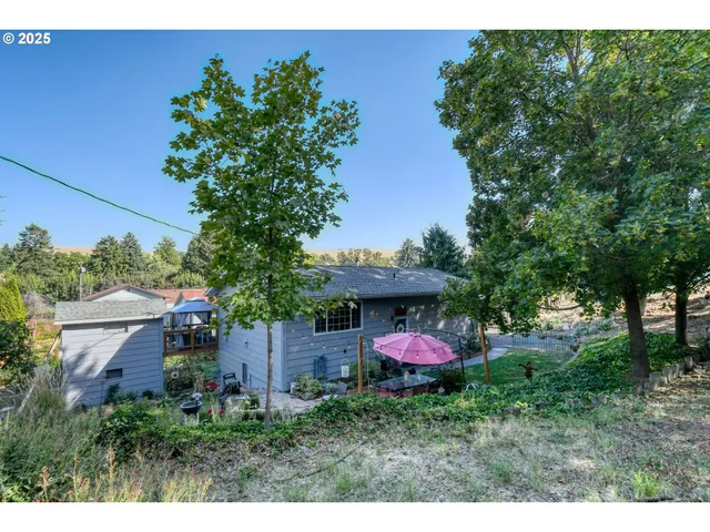 a backyard of a house with a table and a chairs