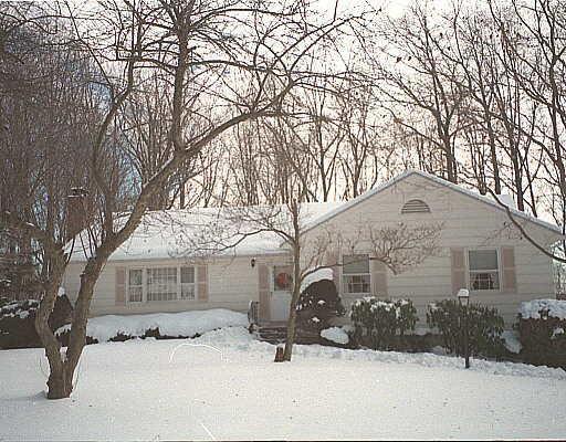 20 Spinning Wheel Road Trumbull, CT 06611 - Photo 1 of 1 a front view of a house with a yard covered in snow
