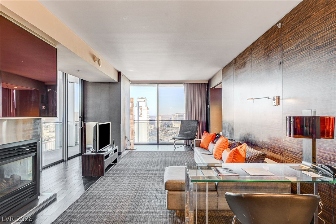 4381 West Flamingo Road, Unit 3002 Las Vegas, NV 89103 - Photo 8 of 59 Floor-to-ceiling glass doors open to a private balcony from this modern living space.