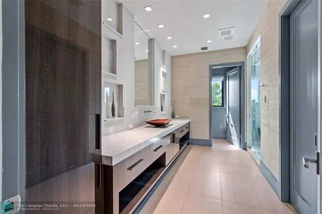 a en suite bathroom with a double vanity sink a large mirror and a bathtub
