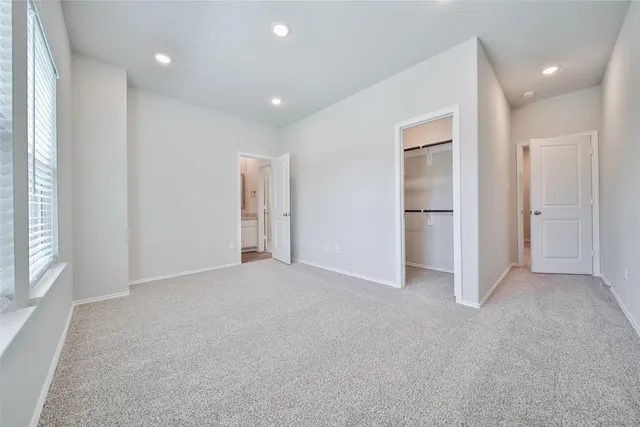 an empty room with windows and closet