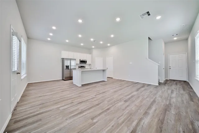 a view of a kitchen with a sink and dishwasher a refrigerator with wooden floor
