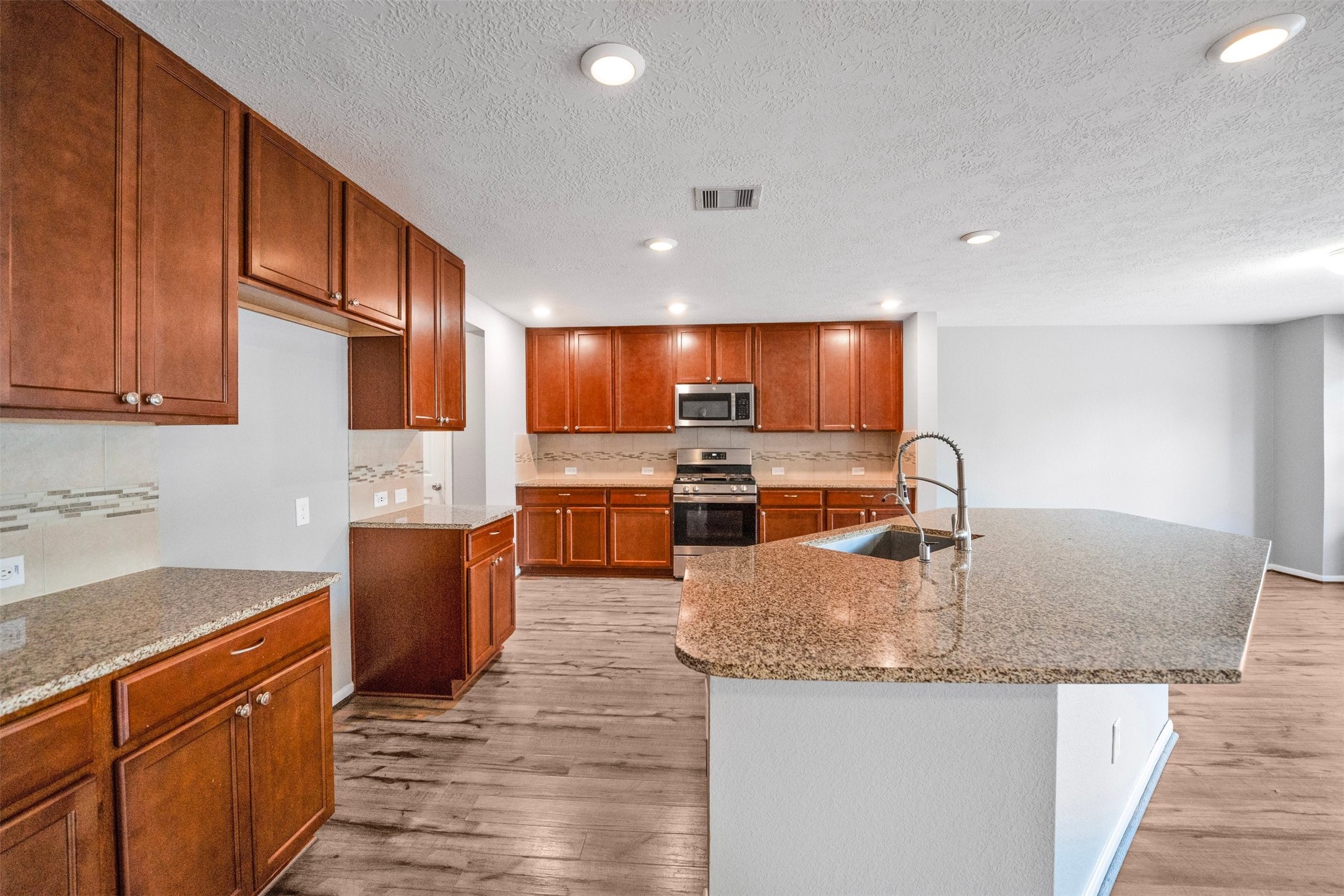 1107 Epworth Ct. Conroe, TX 77304 - Photo 11 of 38 a kitchen with granite countertop a sink a counter top space appliances and cabinets