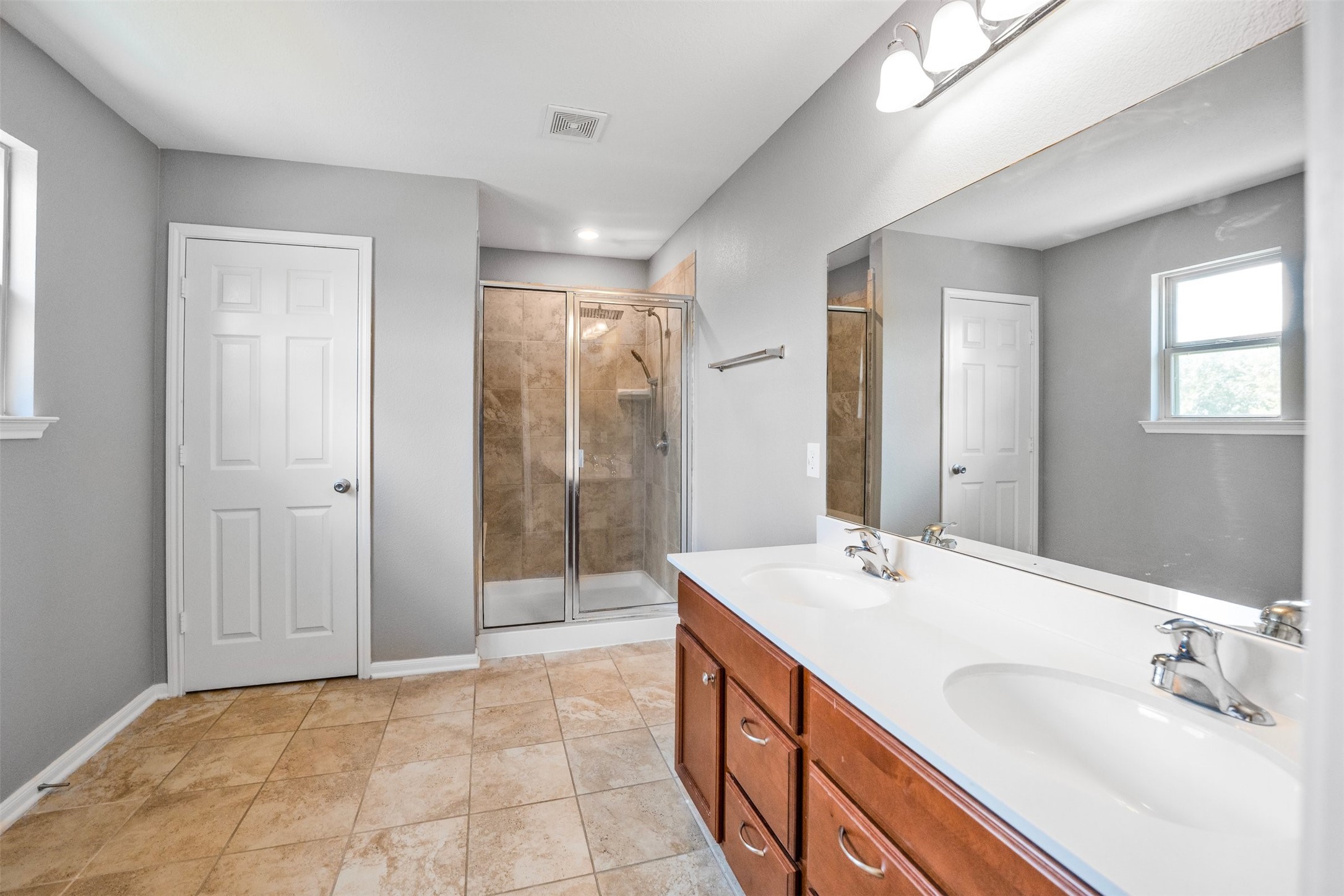1107 Epworth Ct. Conroe, TX 77304 - Photo 24 of 38 a bathroom with a double vanity sink mirror and shower