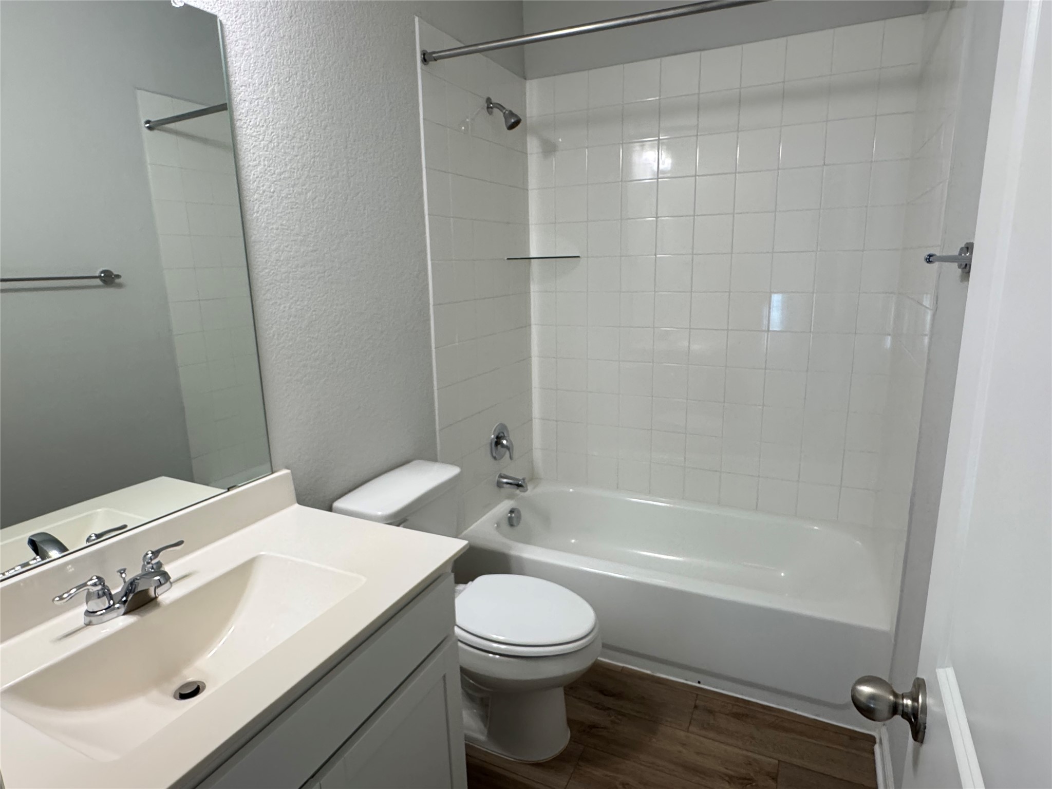 3000 Chisholm Trail Road, Unit 103 Round Rock, TX 78681 - Photo 28 of 32 Hall Bathroom featuring a textured wall, vanity, tub / shower combination, and dark wood-style flooring