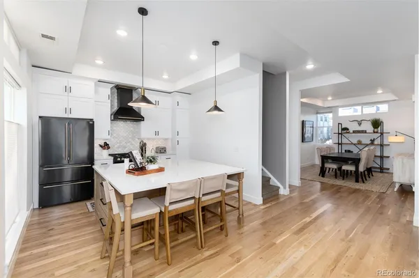 a kitchen with stainless steel appliances kitchen island granite countertop a dining table chairs and stove top oven