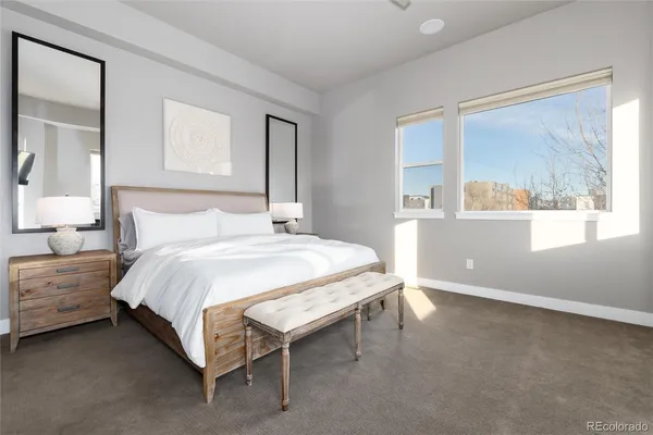 a bedroom with a bed and a painting on the wall