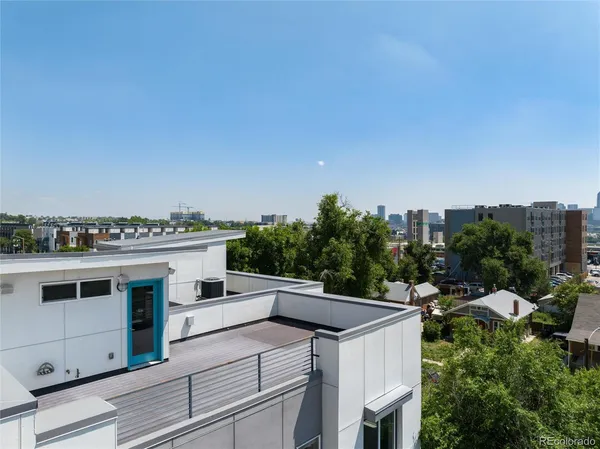 a view of roof deck with seating space and trees in the background