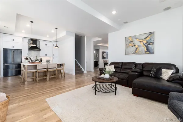 a living room with furniture and a dining table with kitchen view