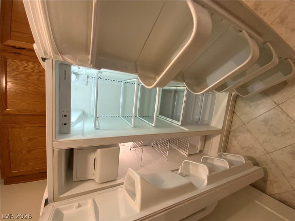 7400 West Flamingo Road, Unit 1039 Las Vegas, NV 89147 - Photo 21 of 40 An empty refrigerator stands ready for stocking in a kitchen setting.