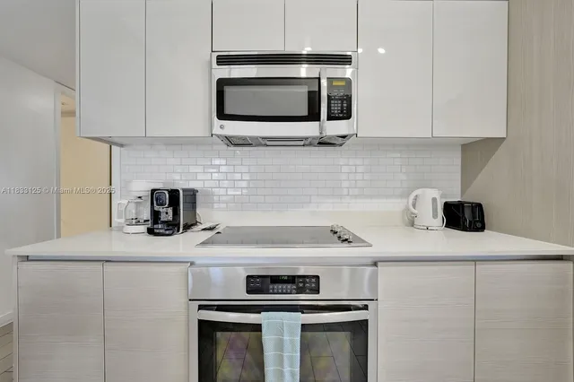 a kitchen with stainless steel appliances a sink a stove a microwave and cabinets
