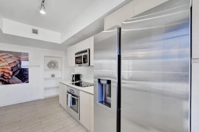 a kitchen with stainless steel appliances a refrigerator and a cabinets