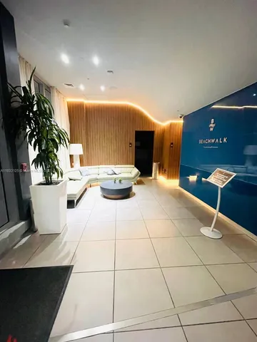 a living room with furniture and potted plants