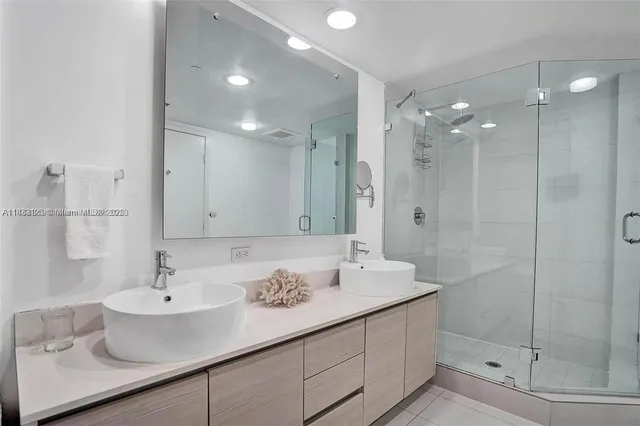 a bathroom with a sink shower and a mirror