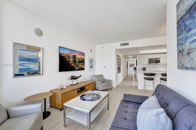a living room with furniture a rug and a flat screen tv