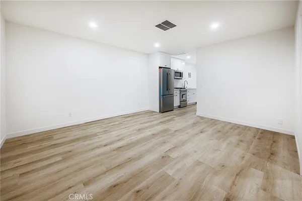 a view of empty room with wooden floor