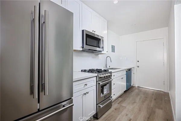 a kitchen with stainless steel appliances a sink stove and refrigerator