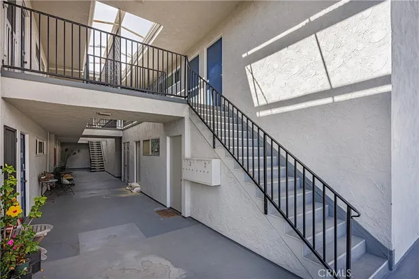 a view of staircase with lots of frames on wall and a window