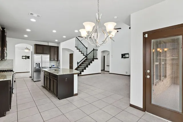 a kitchen with stainless steel appliances granite countertop a refrigerator and a stove