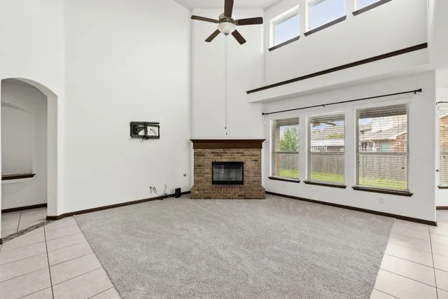 a view of an empty room with a fireplace and a window