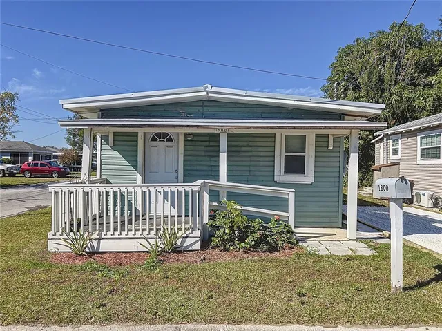 a view of a house with a yard and porch