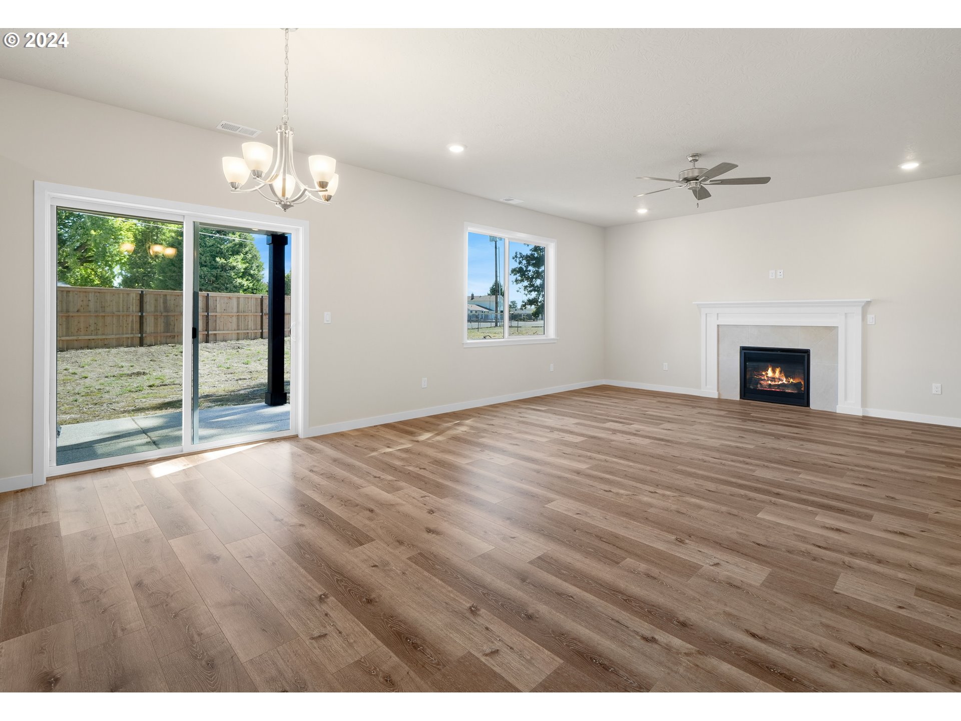 4361 Chaparal Place Albany, OR 97321 - Photo 10 of 36 an empty room with wooden floor fireplace and windows