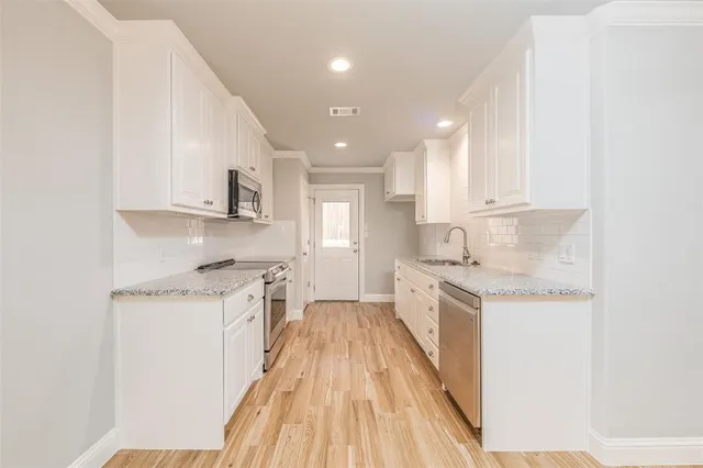 a kitchen with granite countertop white cabinets and white appliances