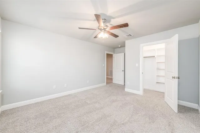 an empty room with closet and fan