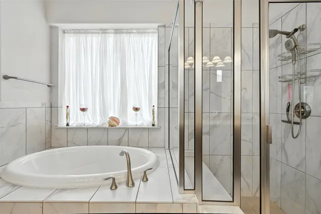 a white bath tub sitting next to a shower
