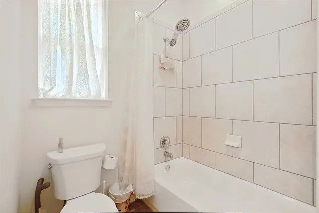 a white bath tub sitting next to a white toilet