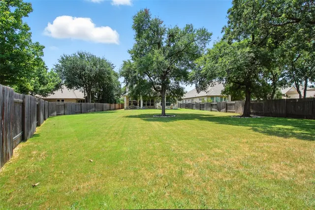 a view of a house with a big yard and large trees