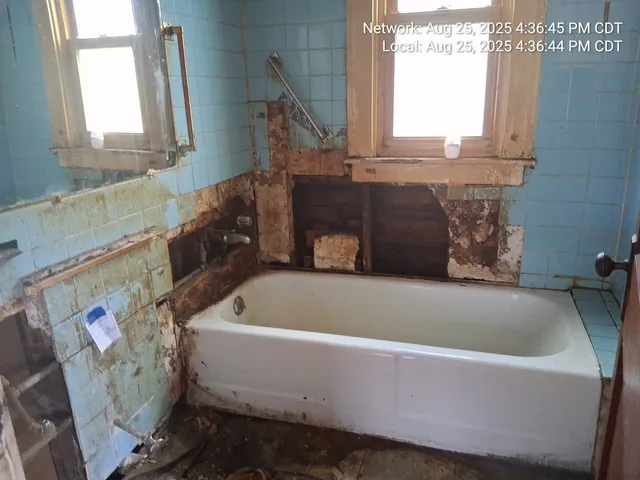 a bath tub sitting in a bathroom next to a window