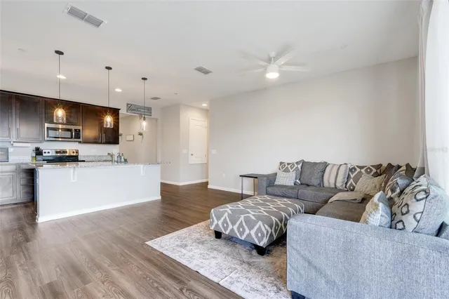 a living room with furniture and kitchen view