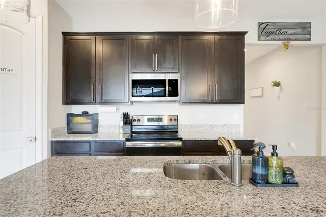 a kitchen with stainless steel appliances granite countertop a refrigerator and a stove top oven