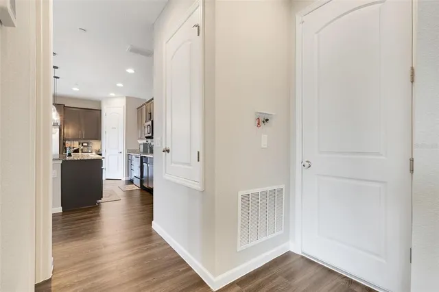 a view of a kitchen with wooden floor and a hallway