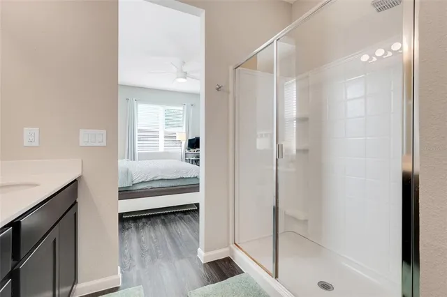 a bathroom with a glass shower door and a sink