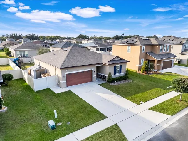 an aerial view of a house with a yard table and chairs