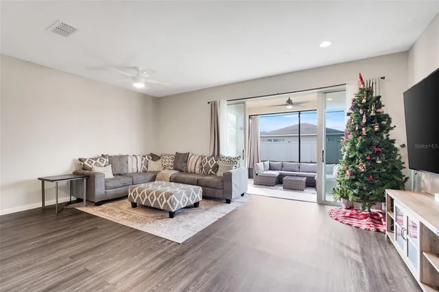 a living room with furniture potted plant and a large window