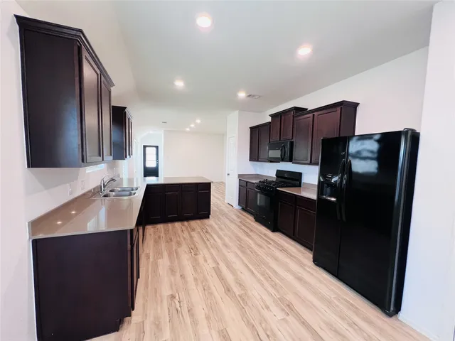 a kitchen with stainless steel appliances a sink stove and refrigerator