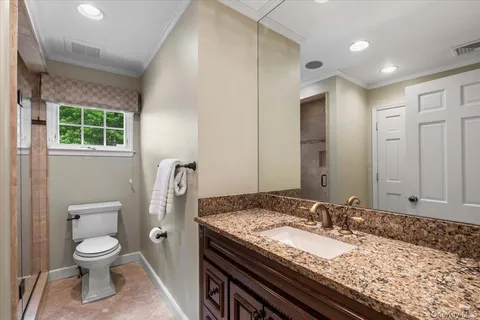 a bathroom with a granite countertop sink toilet and shower